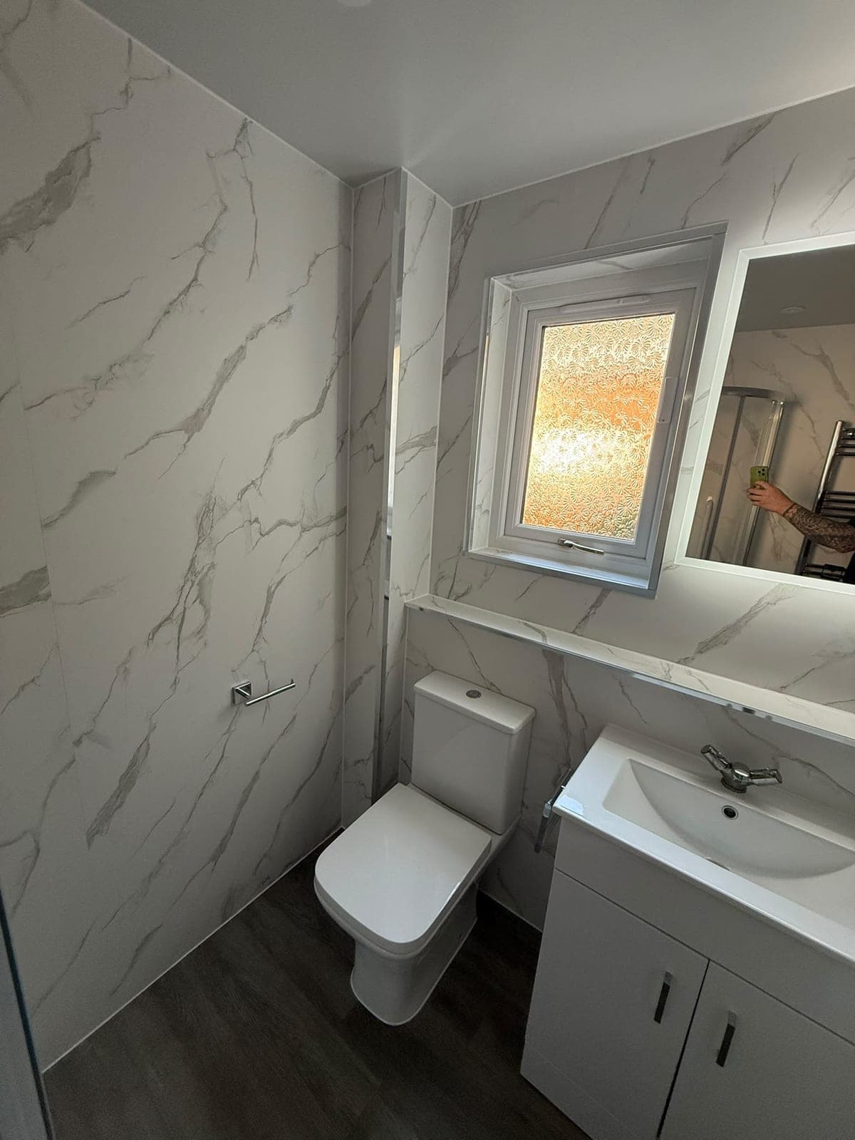 Marble-effect wall panels, WC and vanity basin in an Edinburgh easy-access shower room